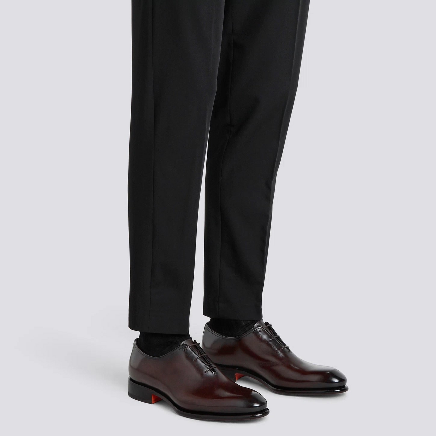 scarpe stringate di lusso marroni indossate con pantaloni neri eleganti, dettagli raffinati e stile classico