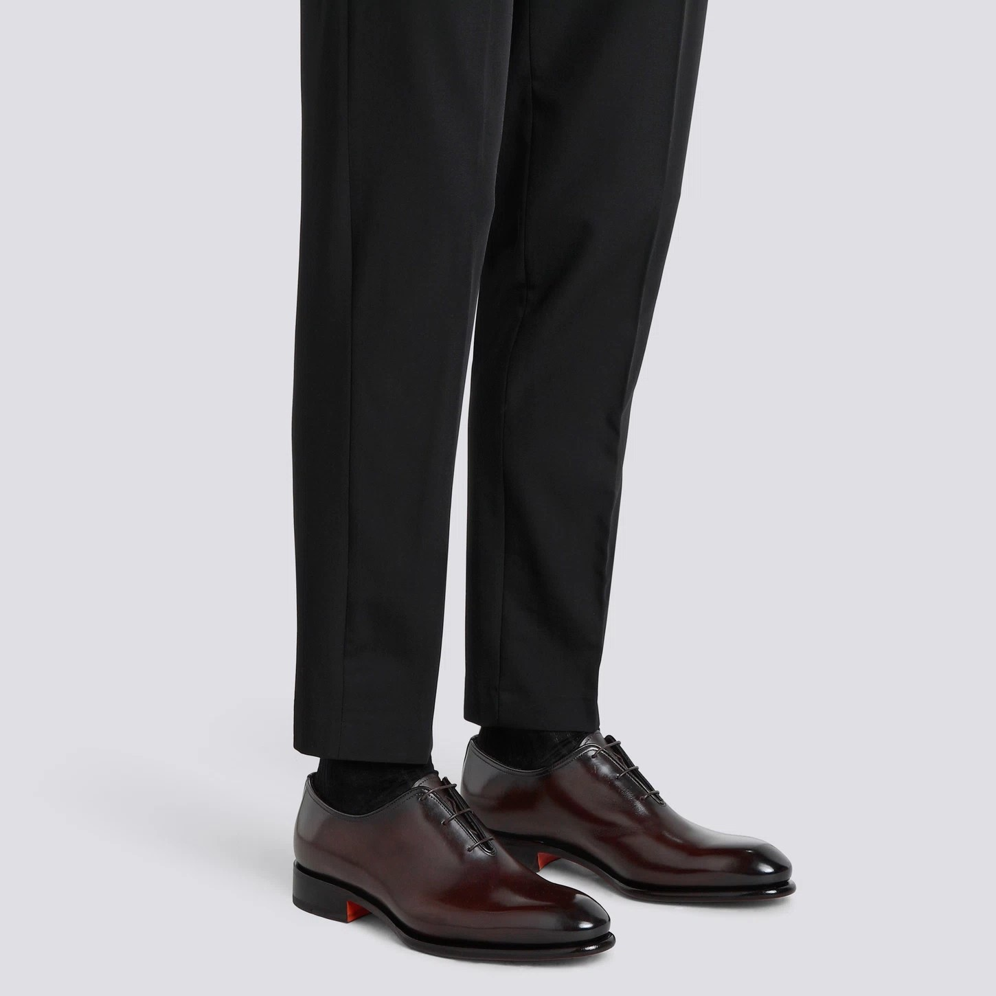 scarpe stringate di lusso marroni indossate con pantaloni neri eleganti, dettagli raffinati e stile classico