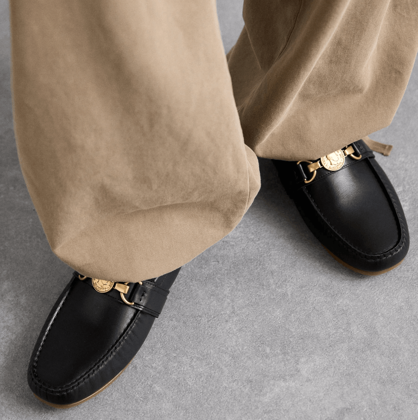 Moschino mocassini pelle 210Z3L04D100 in pelle nera, indossati con pantaloni beige