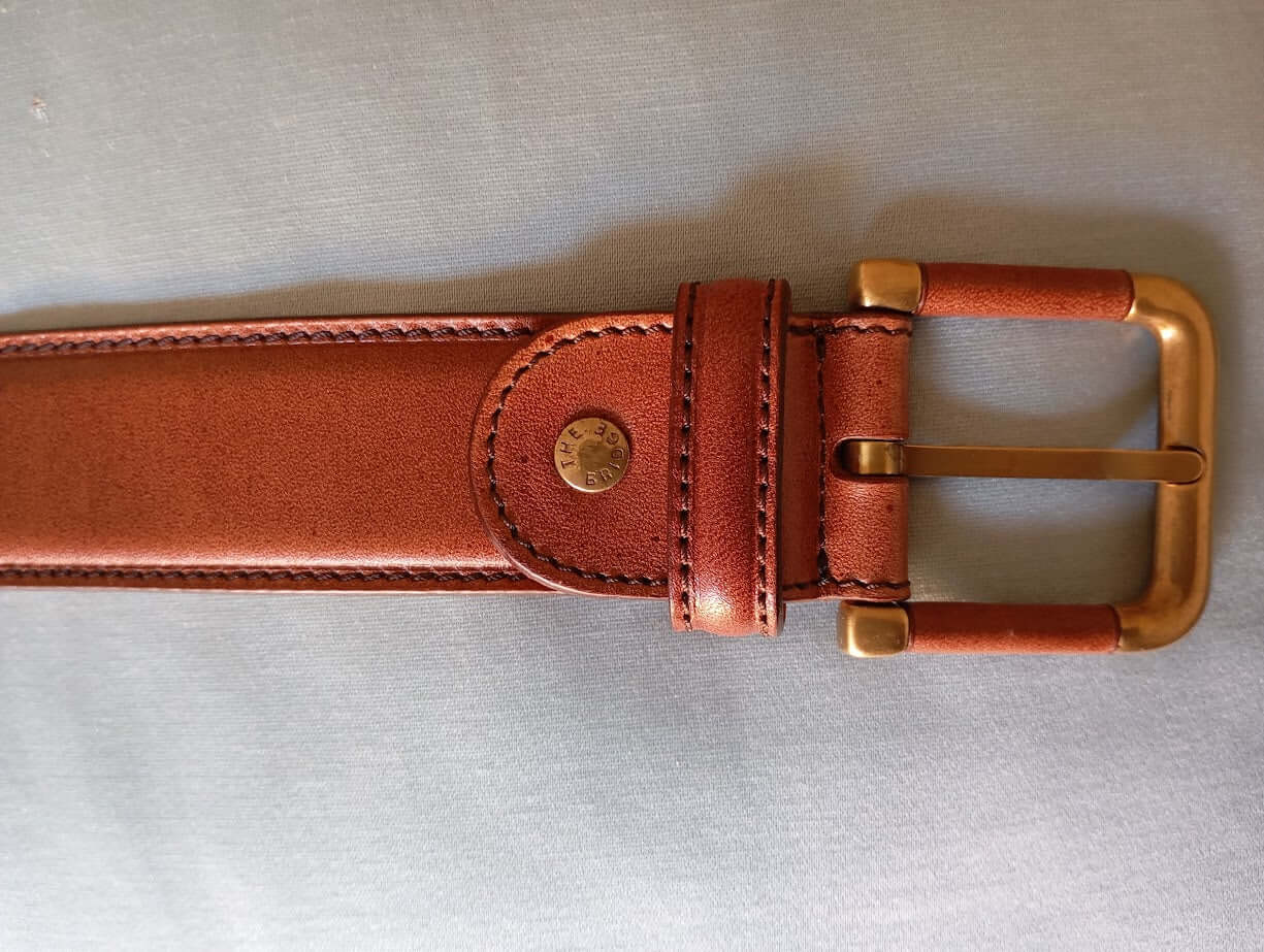 Cintura in vitello eleganza italiana con fibbia dorata in metallo e design accorciabile.