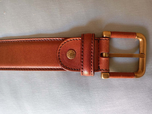 Cintura in vitello eleganza italiana con fibbia dorata in metallo e design accorciabile.